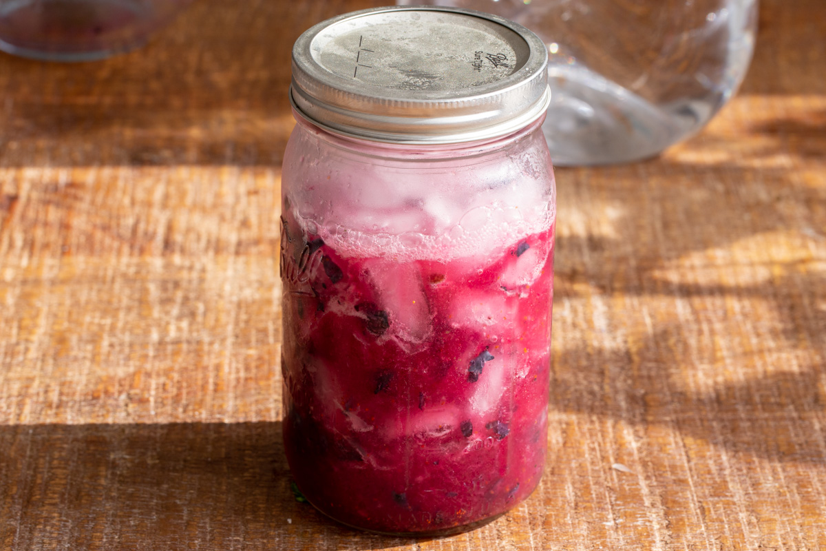 fresh blueberry lemonade served in a mason jar with the lid on