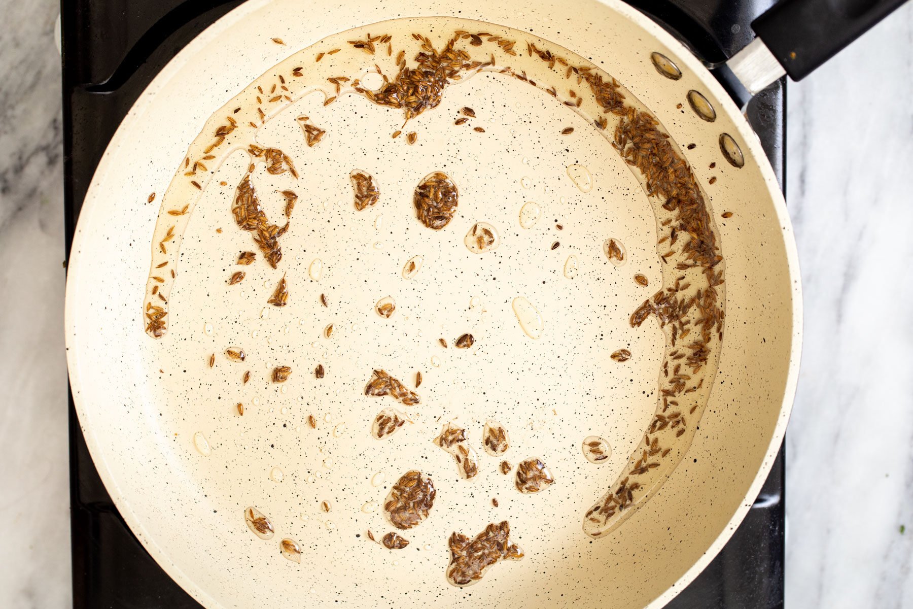 cumin seeds frying in a pan