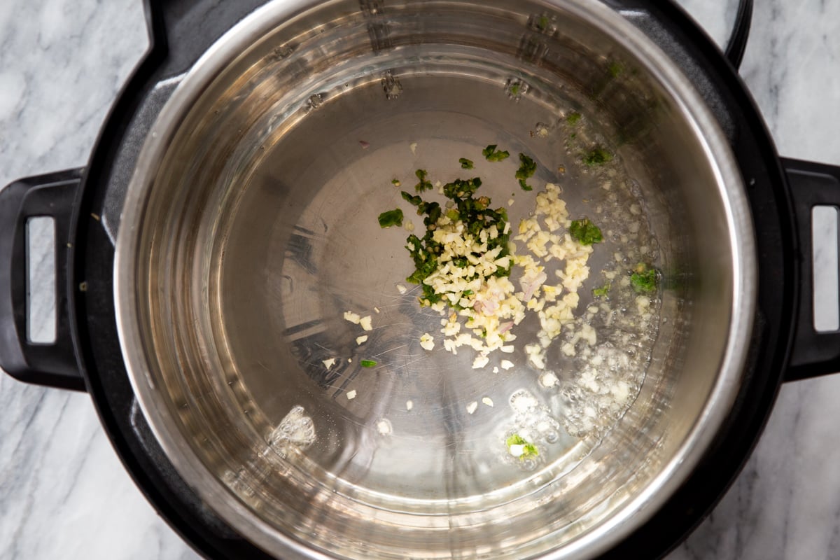 onion and green chili frying on sautee mode in an Instant pot
