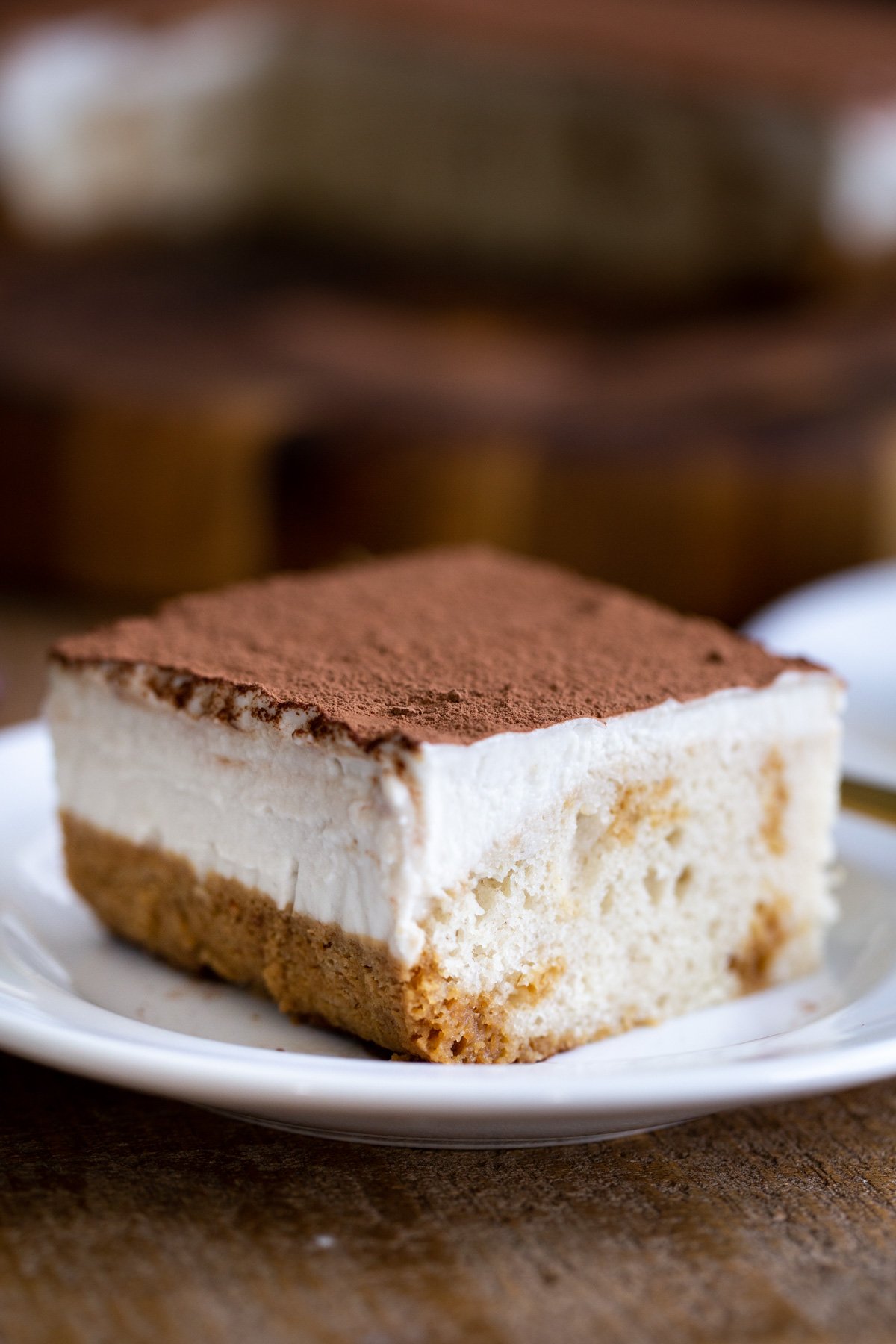 a slice of vegan tiramisu sheet cake on a white cake platter