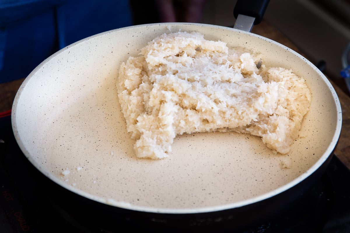 shredded coconut burfi paste in a sauteeing pan