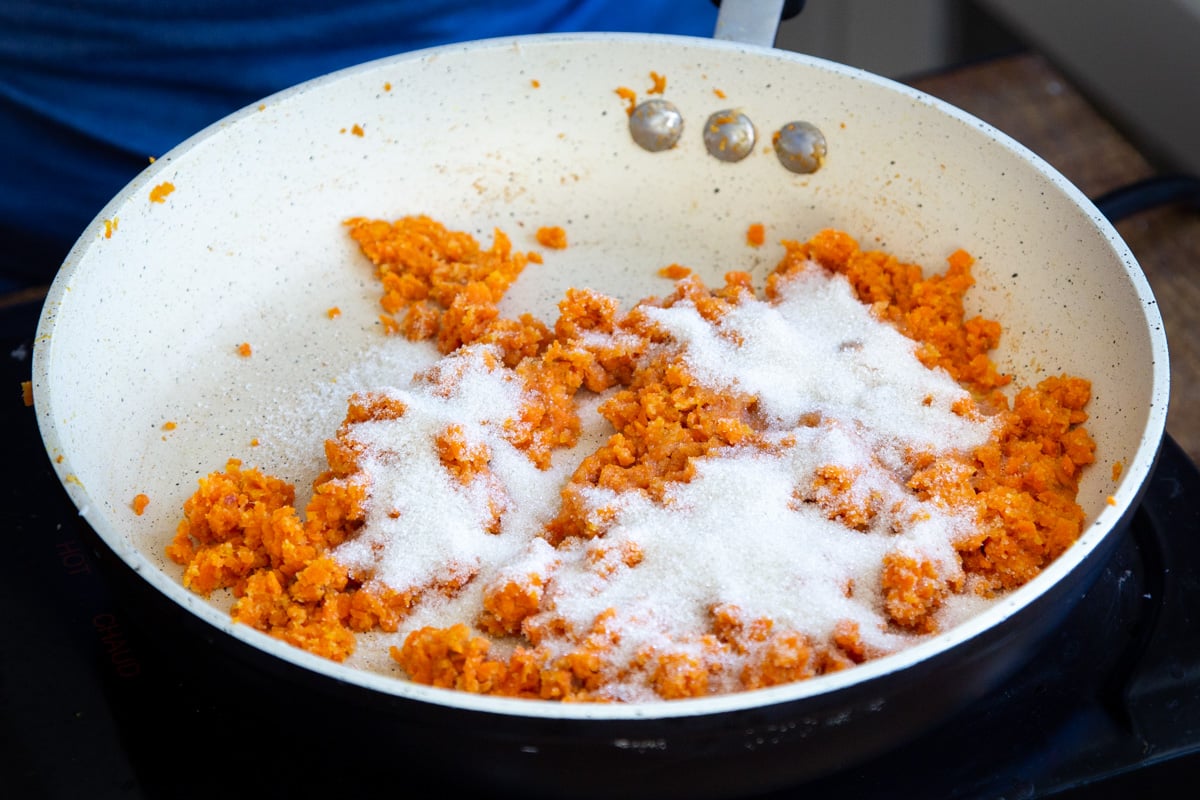 sugar and shredded sauteed carrots in a sauteeing pan