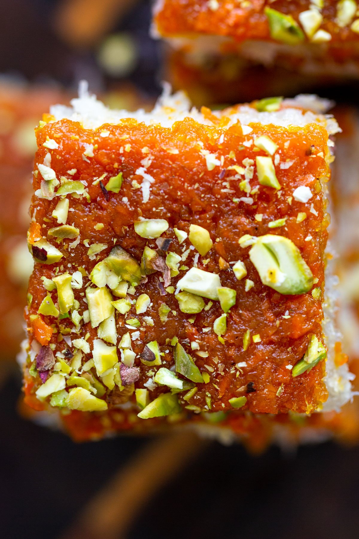 carrot halwa coconut burfi bars topped with chopped pistachios