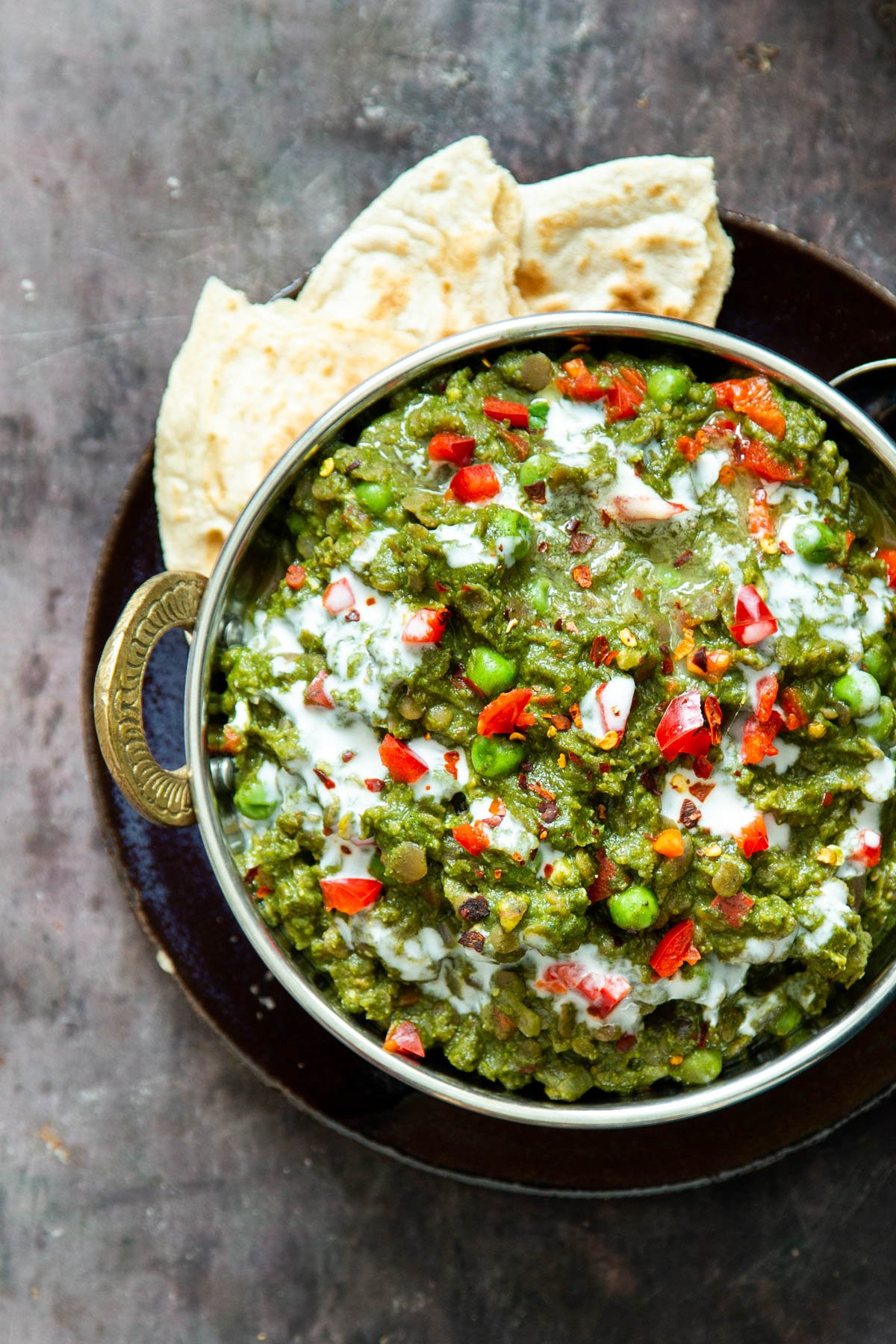 vegan green keema curry in an Indian pot served with a side of flatbread