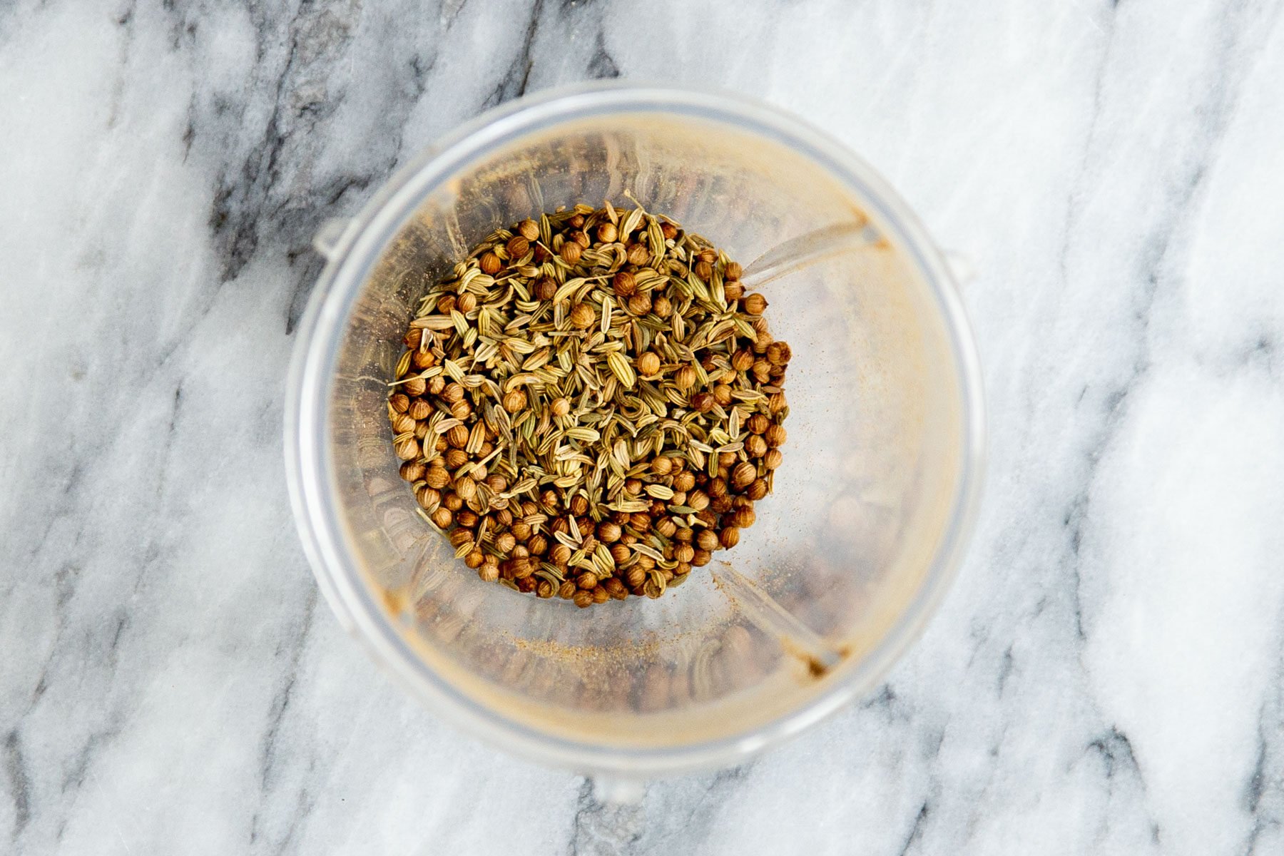 fennel seeds and coriander in a grinder
