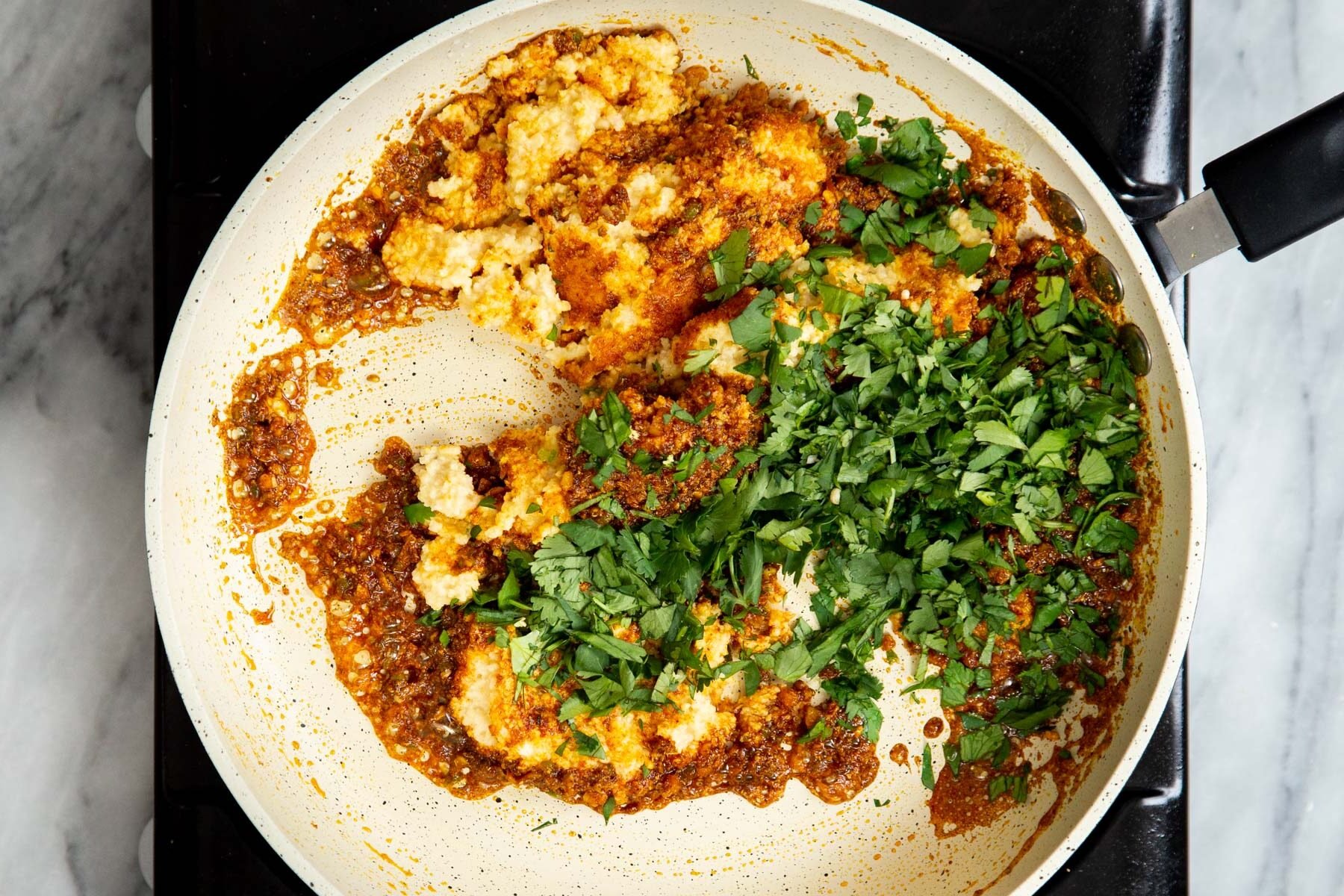 ground ural dal, cilantro and spice blend in a sauteeing pan