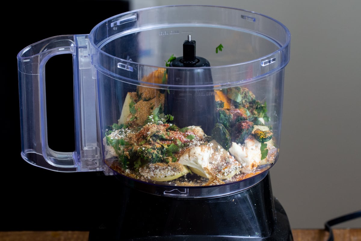 veggies and flour in the container of a food processor