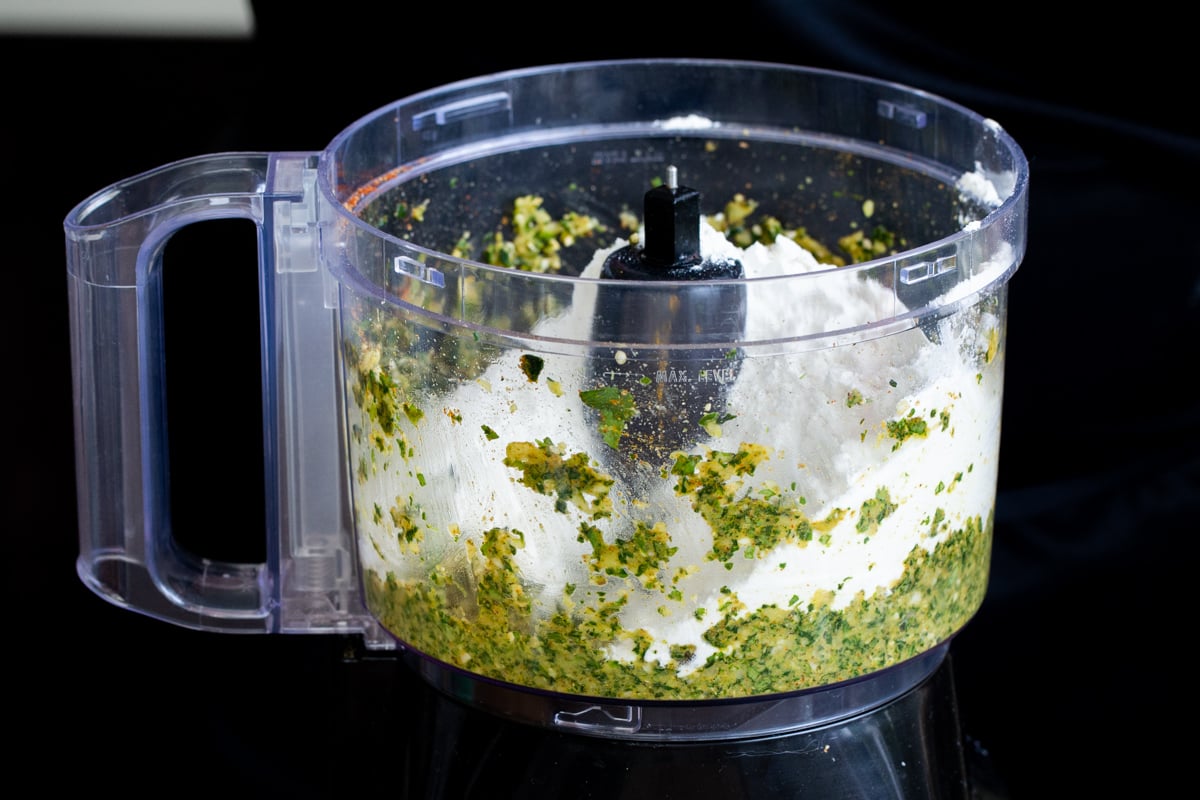 flour and chopped veggies in a food processor container