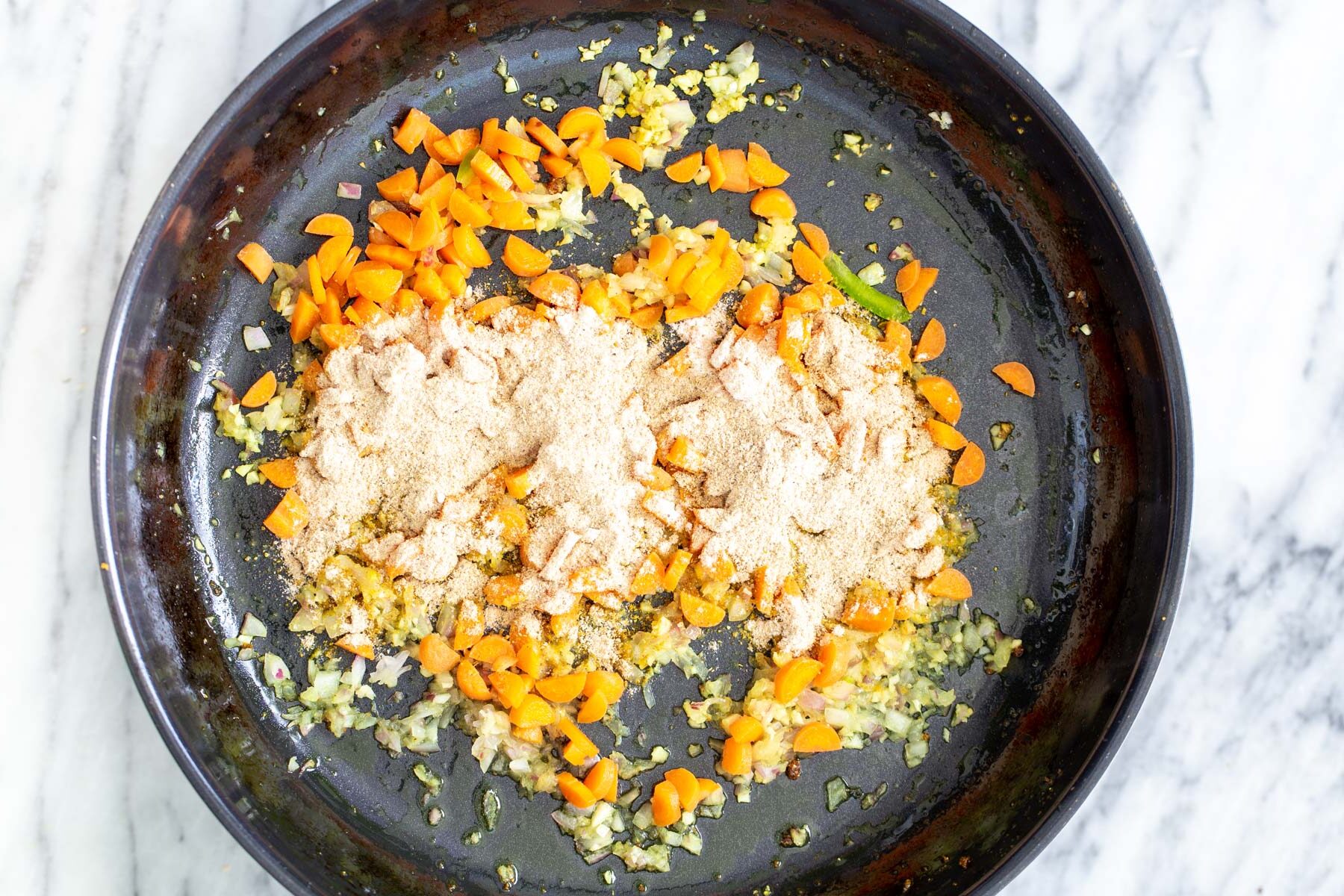 chopped sauteed veggies in a black skillet