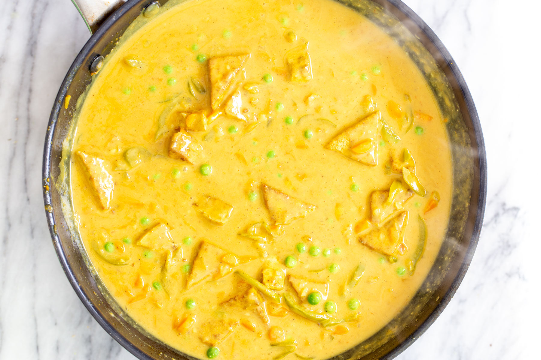 creamy Malaysian tofu coconut curry in a sauteeing pan