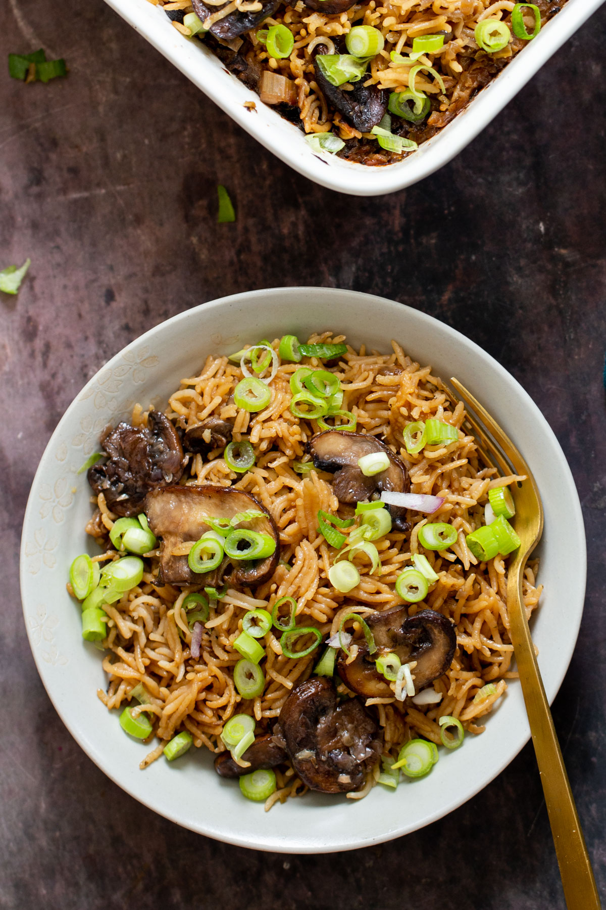 a plate with mushroom baked rice sprinkled with green onions
