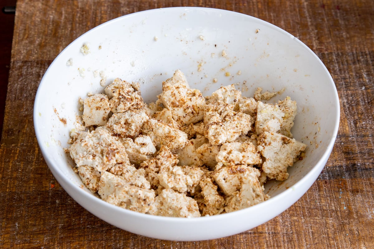 torn up marinated tofu in a white bowl