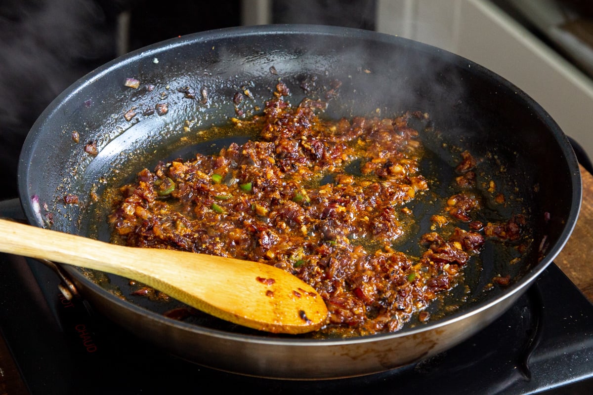 minced onions frying with spices in a black pan