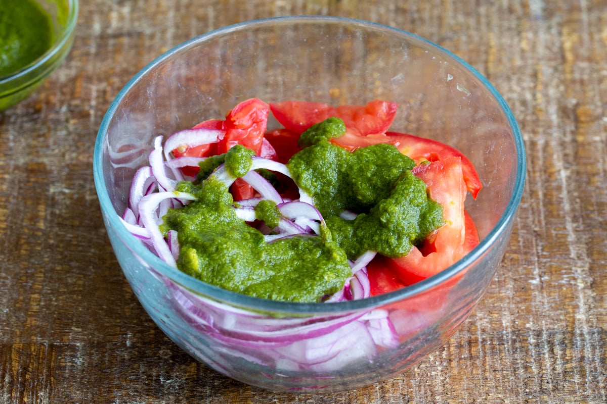 onion, tomatoes and mint chutney in a glass bowl