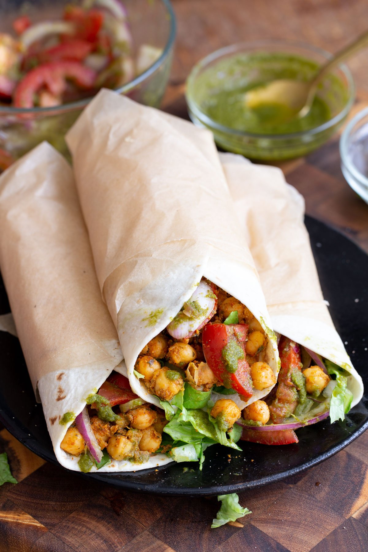 three Indian spiced chickpea wraps filled with tomtoes and lettuce