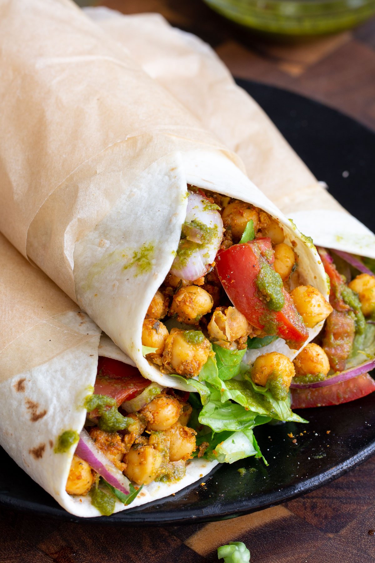 three wraps filled with chickpeas tomatoes, onions and tomatoes