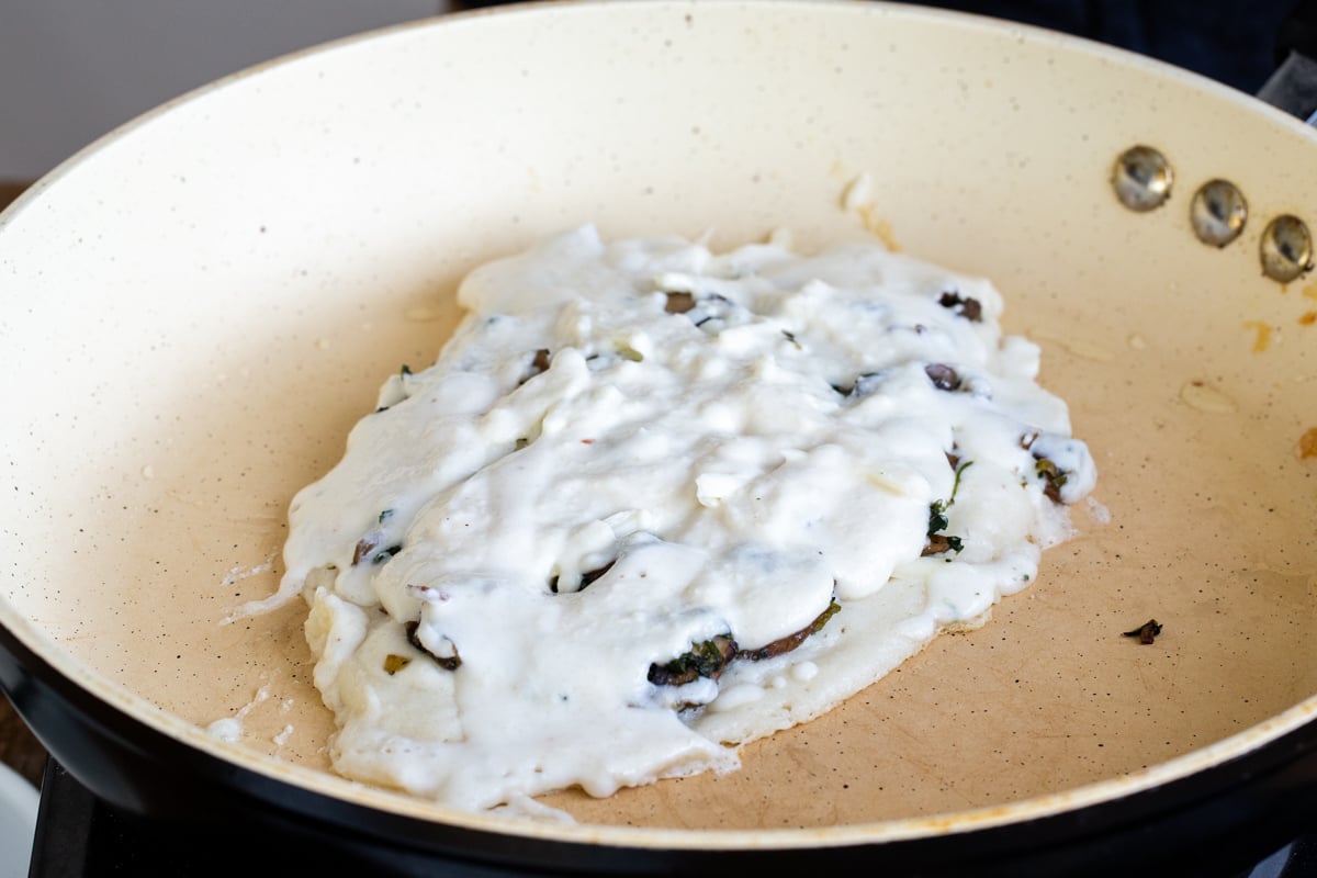 spinach mushroom stuffed vegan naan baking in a pan