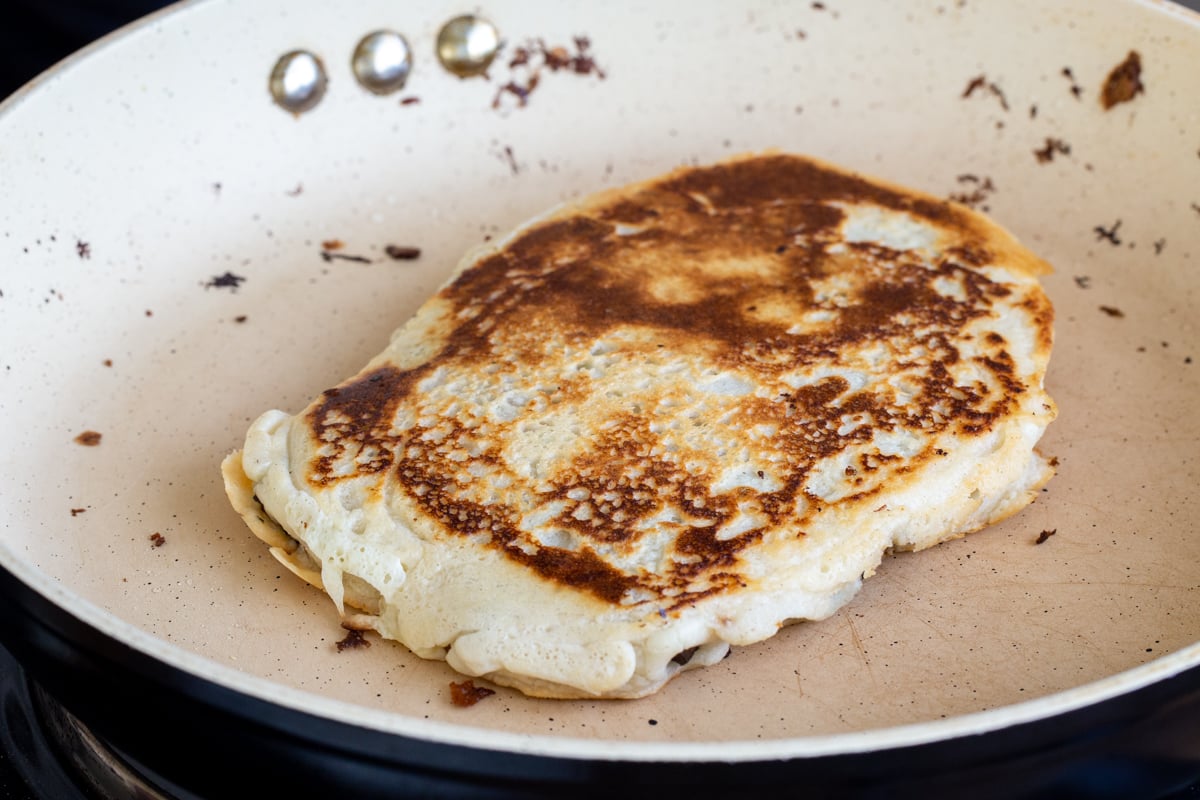 vegan stuffed almond flour naan baking in a pan
