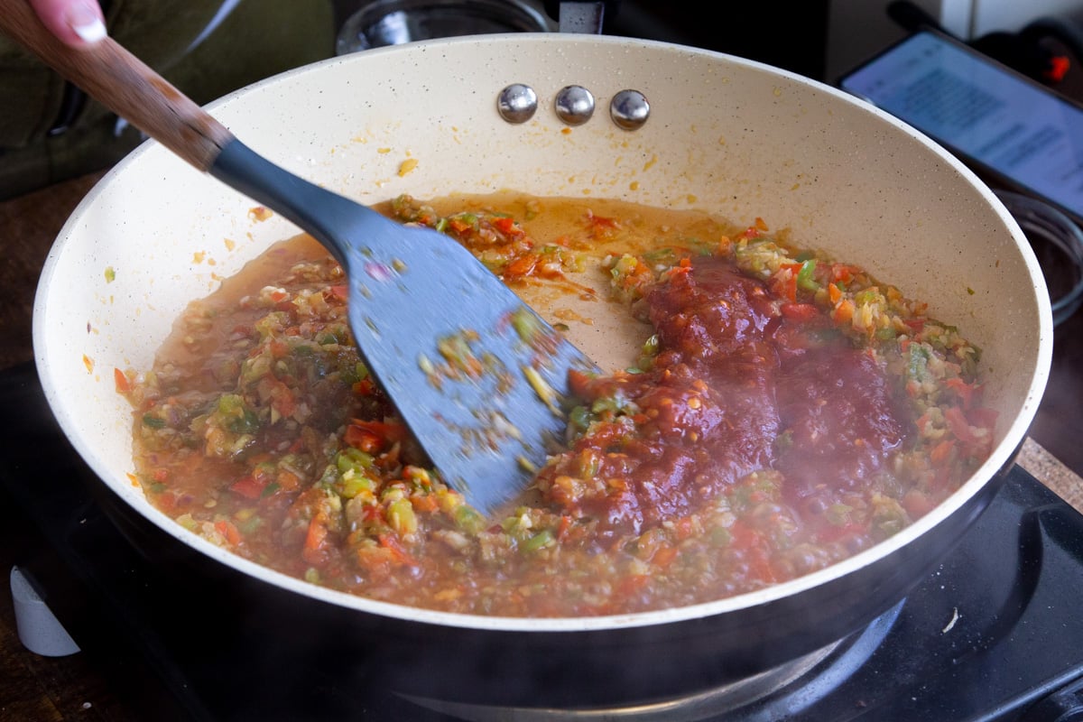 Manchurian sauce being prepared in a white saucepan