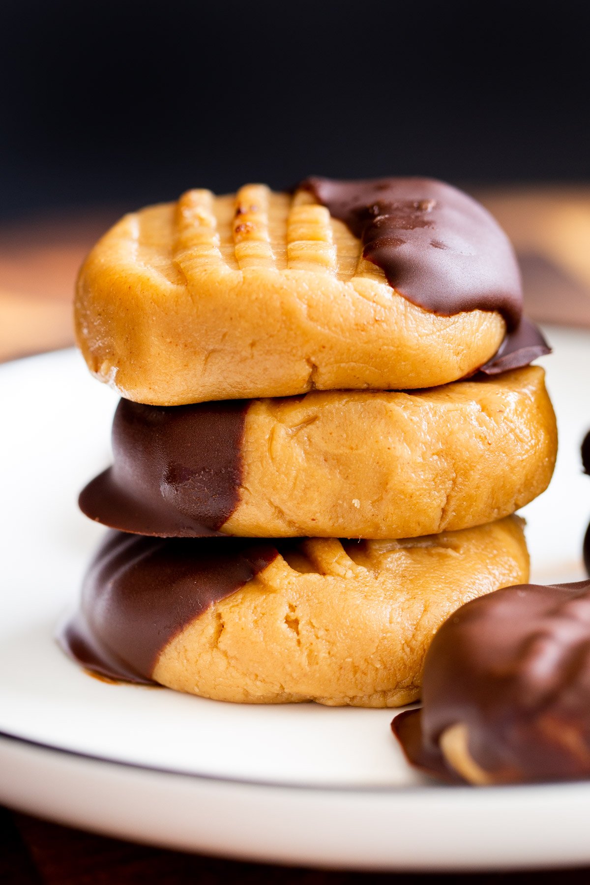a stack of vegan no bake peanut butter cookies dipped in chocolate