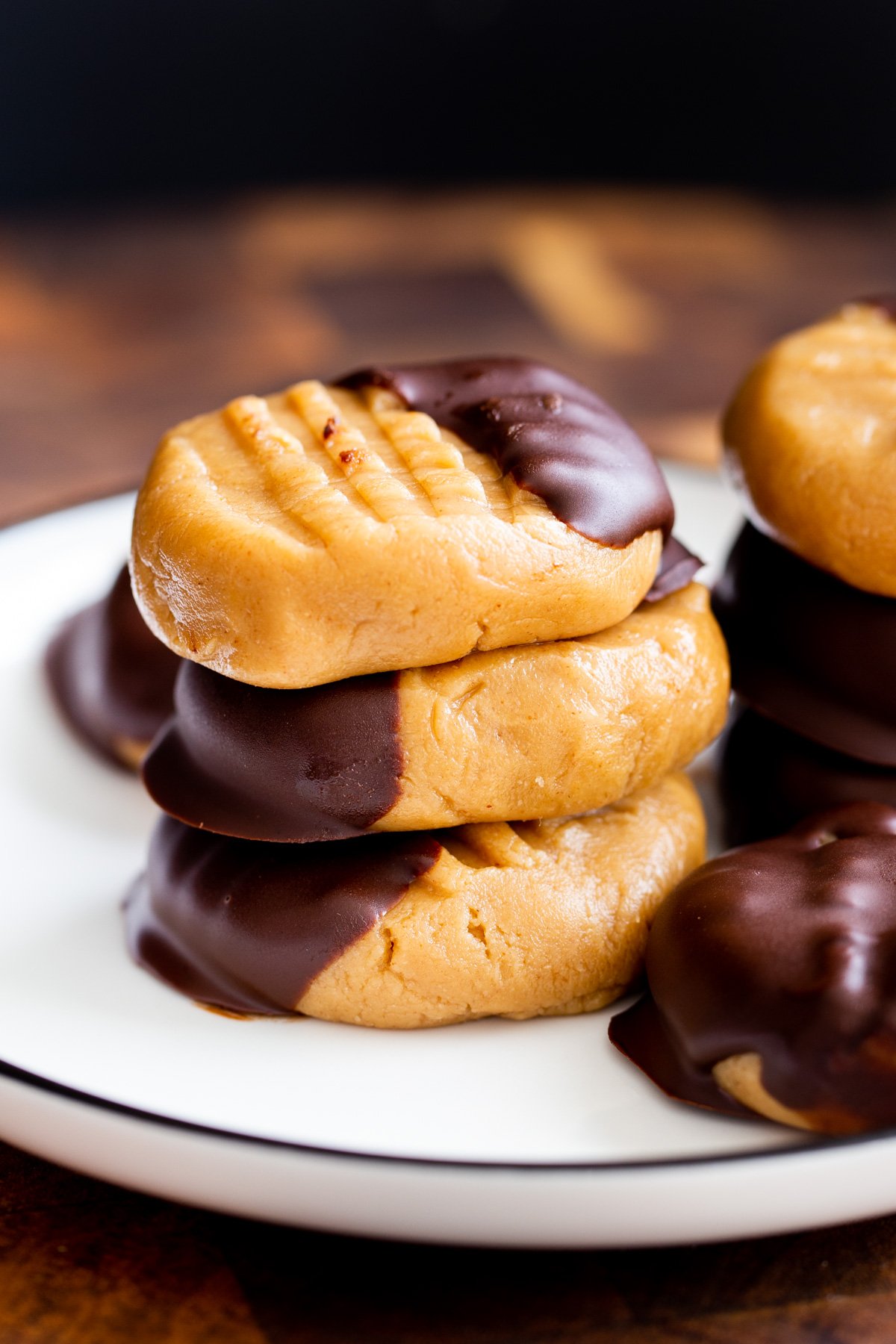a stack of no bake peanut butter cookied dipped in chocolate on a plate