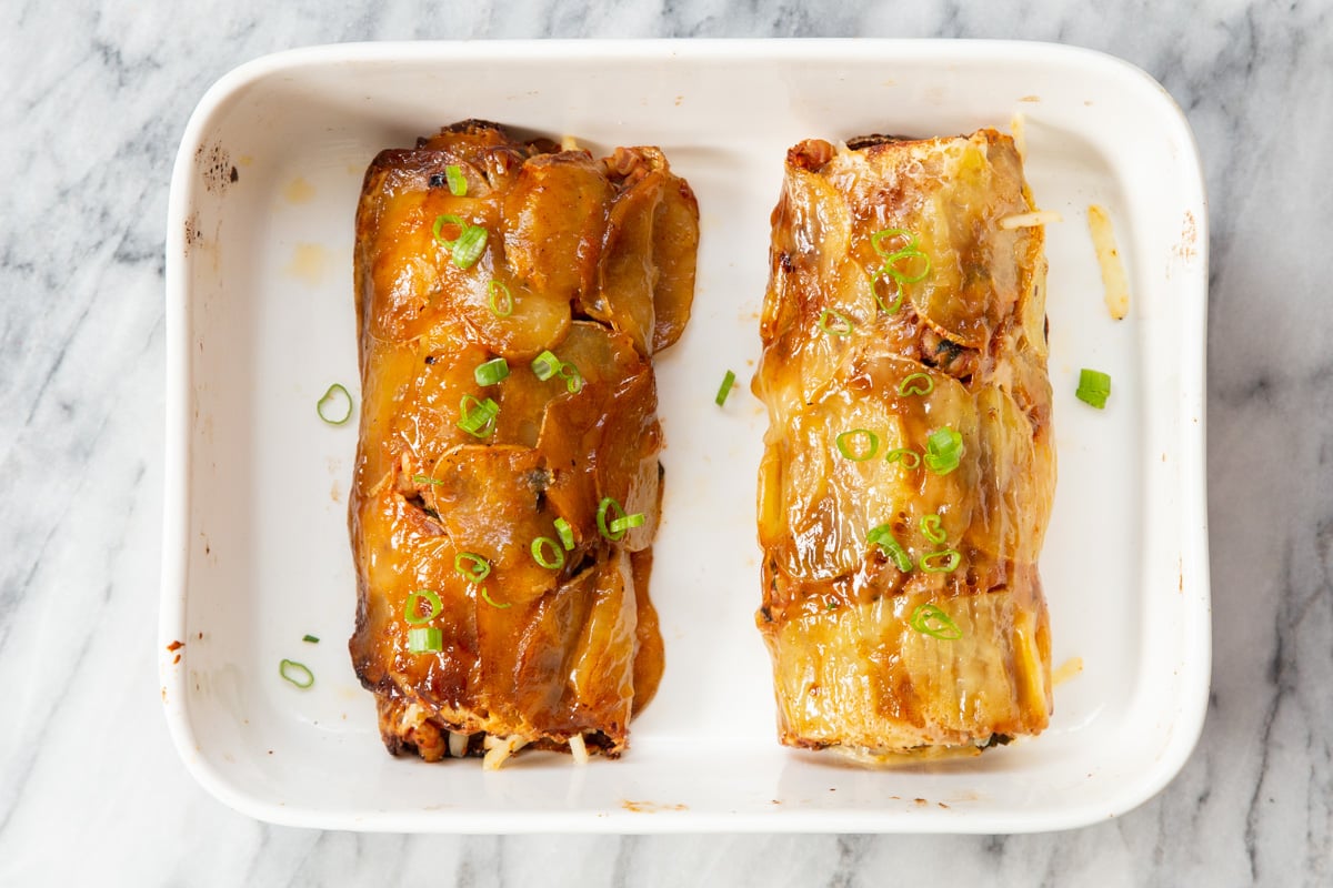 two vegan scalloped potato rolls in a casserole dish