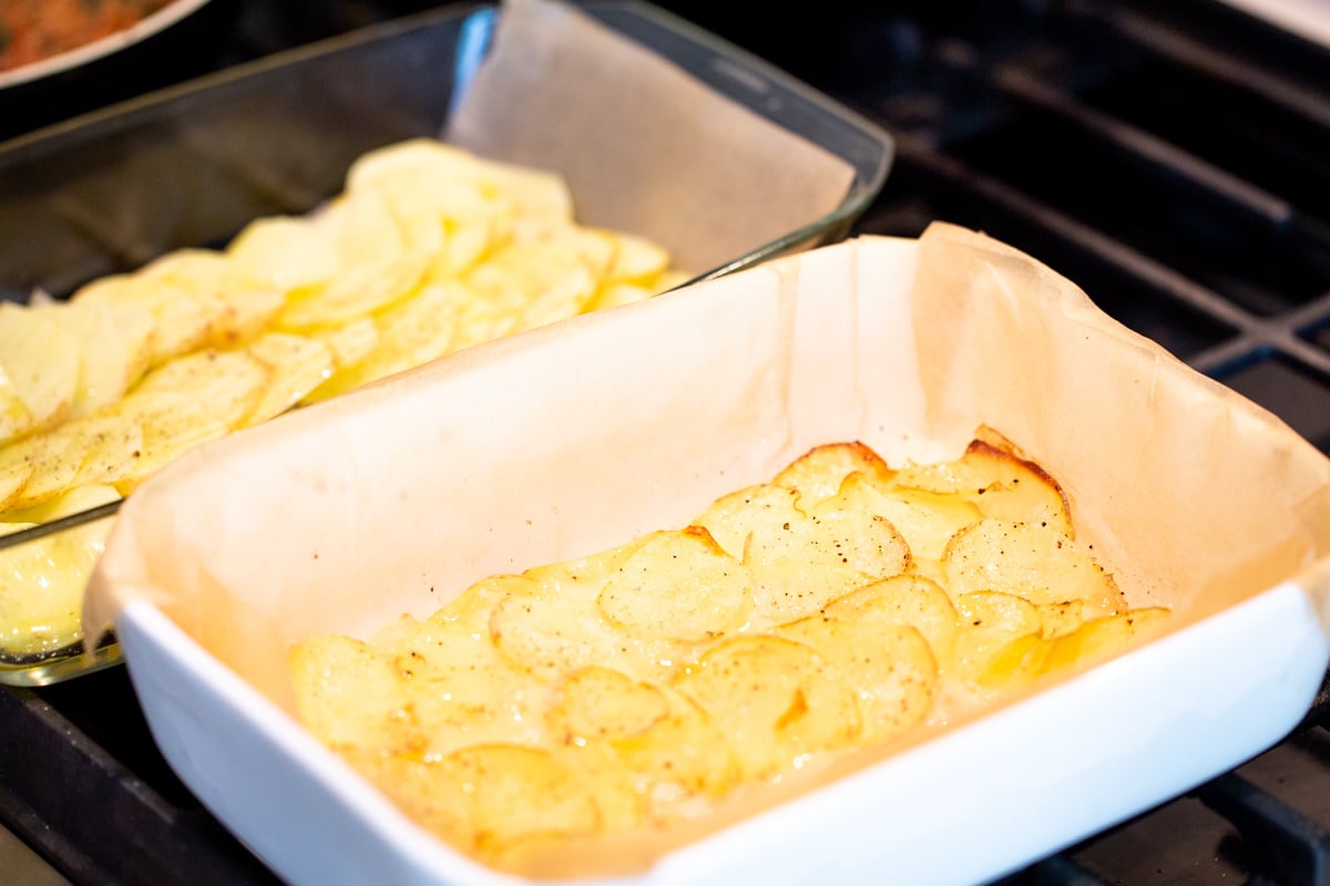 vegan scalloped potatoes baking in two casserole dishes