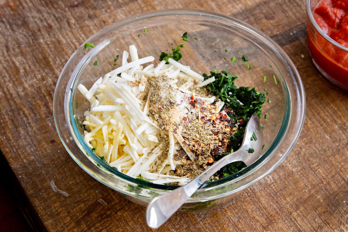 cheese being mixed with spinach herbs and spices