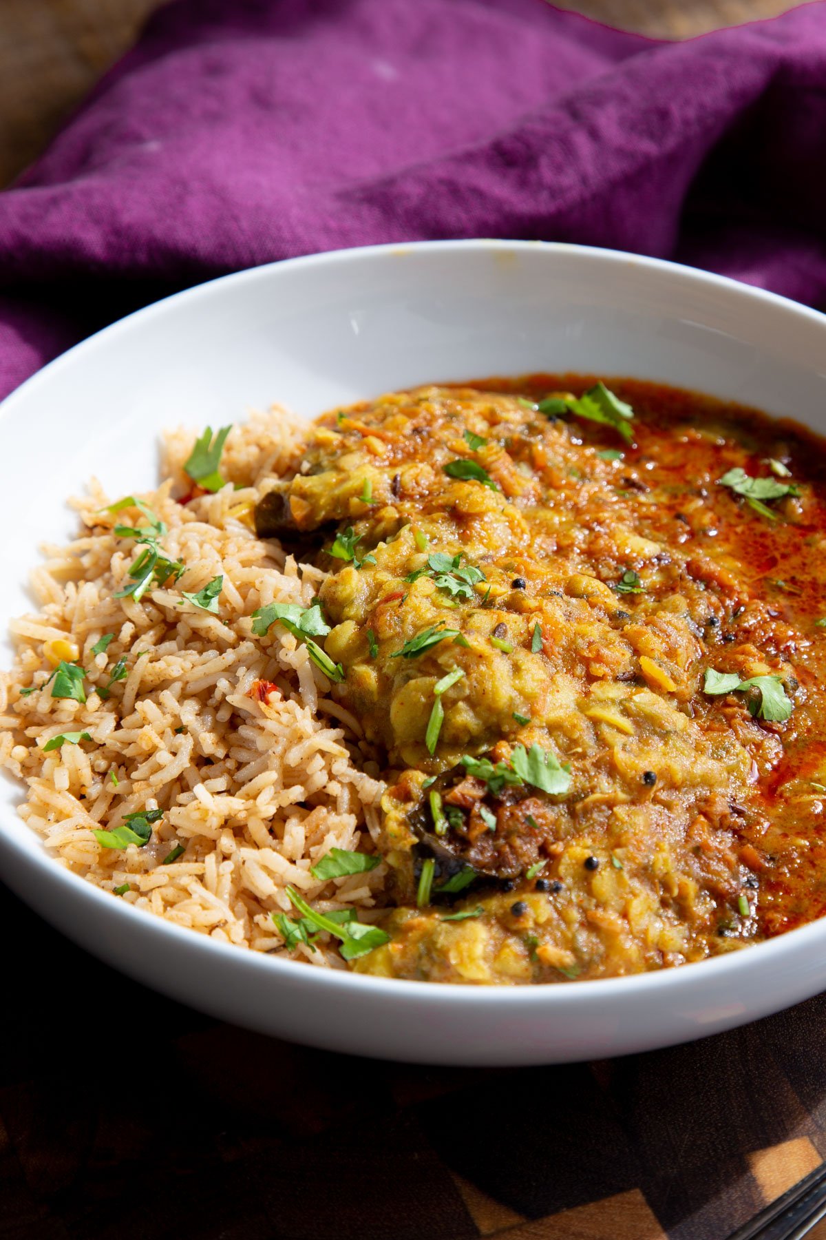Indian chataka dal served over rice in a white bowl
