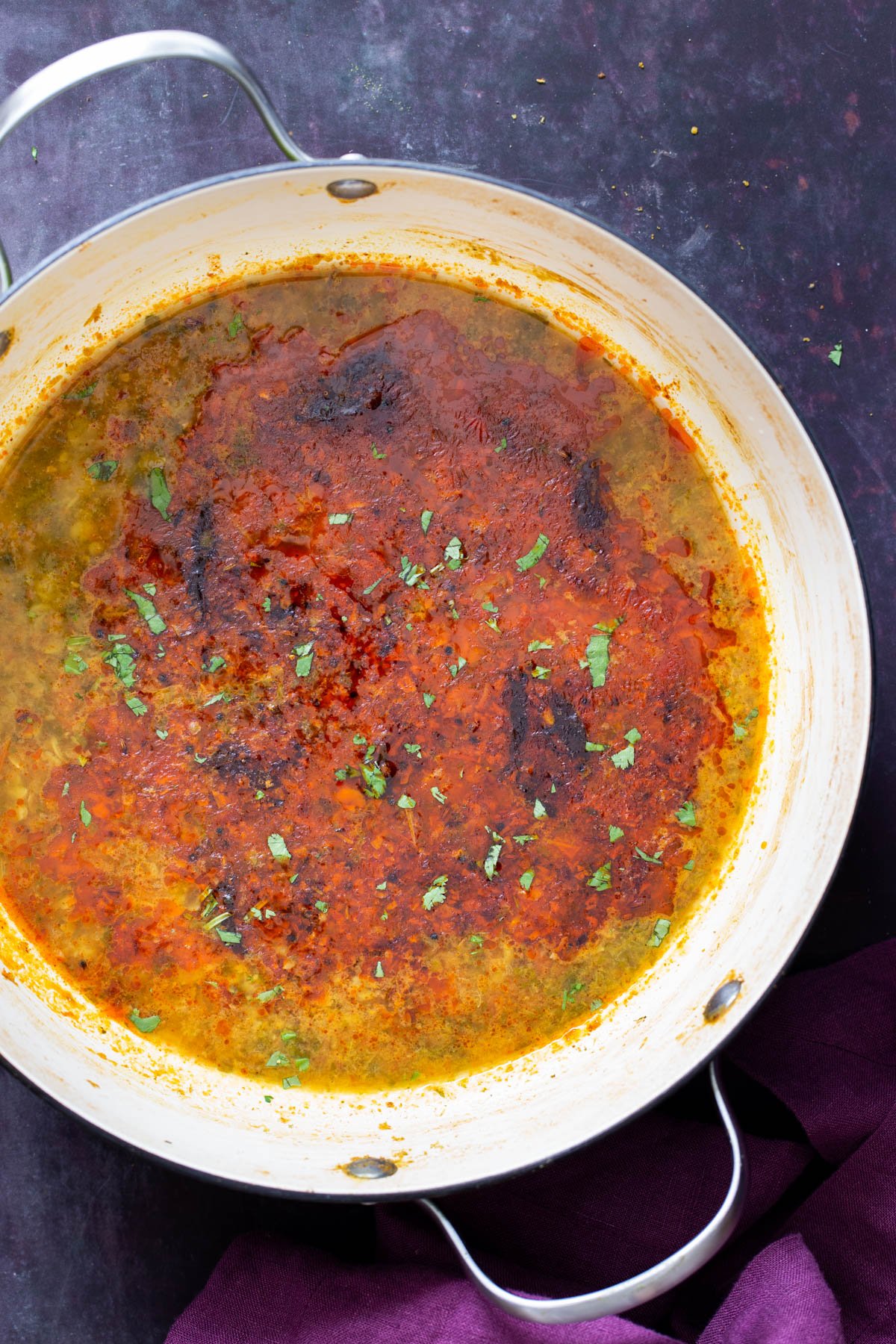 Indian chataka dal in a green and white saucepan