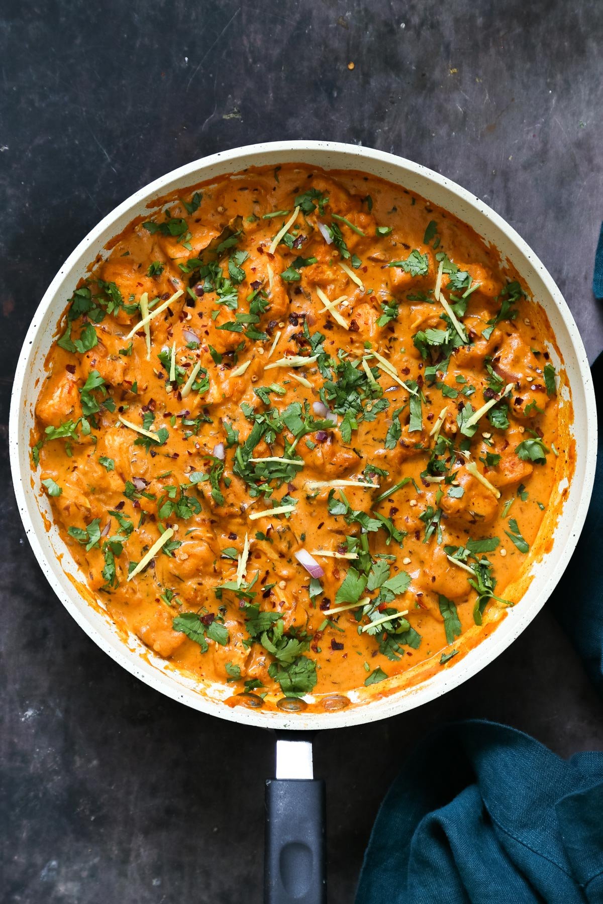 a pan with Indian Lasooni Chicken made with tofu sprinkled with cilantro