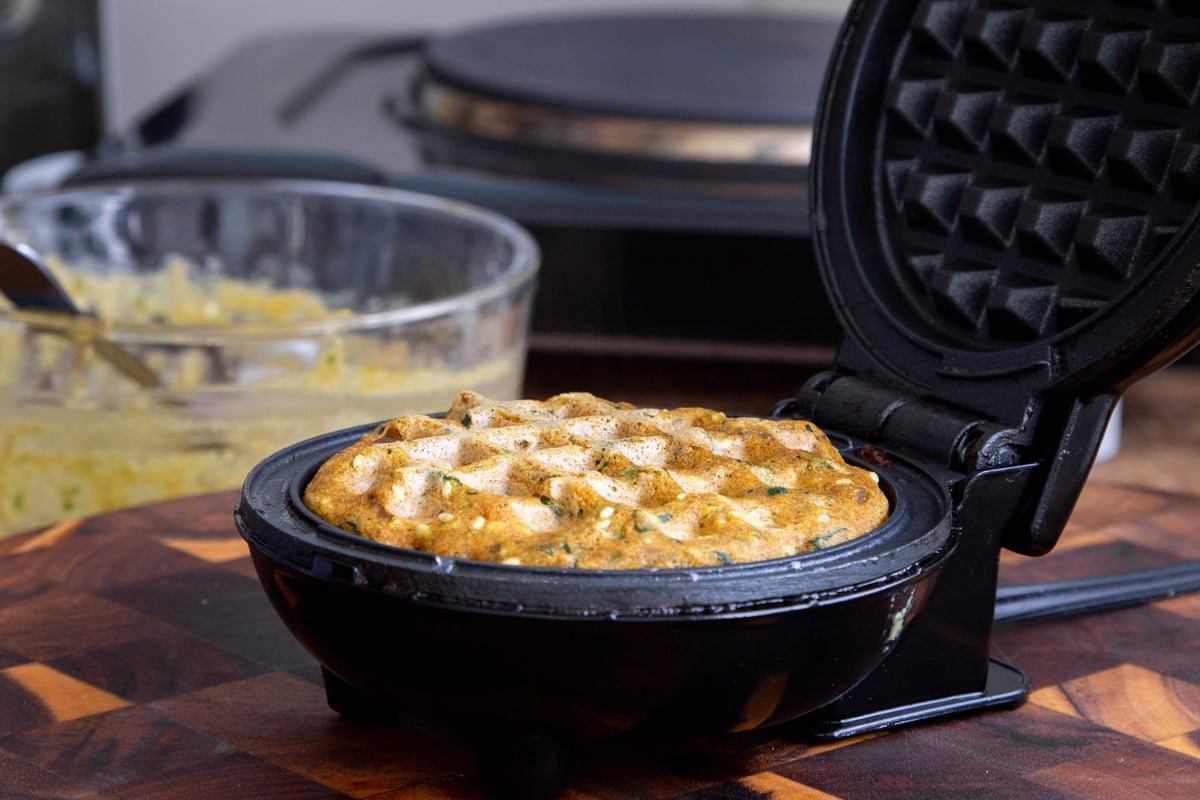 lentil flour waffle baking in a waffle iron
