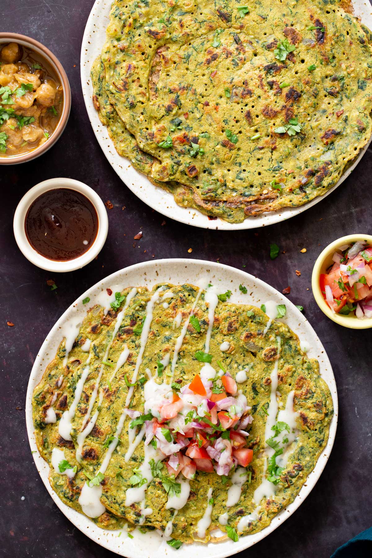 lentil flour pancakes on two white plates topped with some tomato salsa