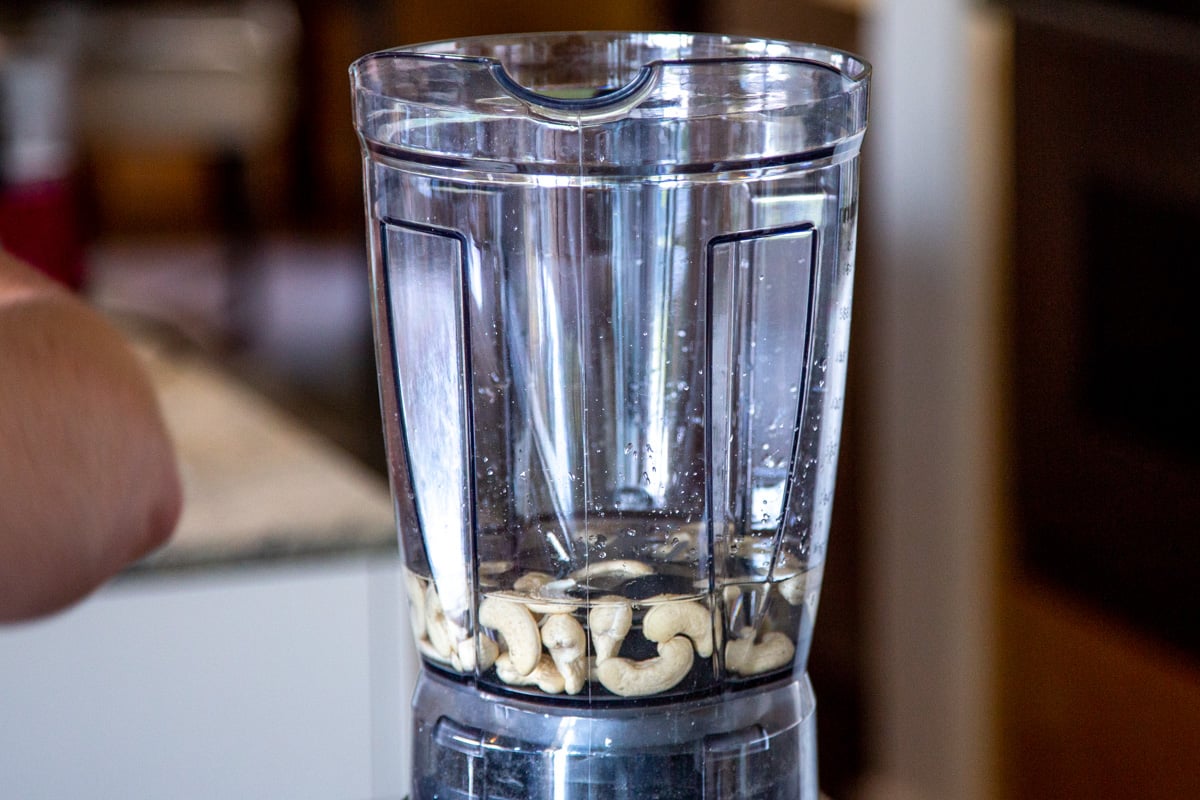 a blender with water and cashews