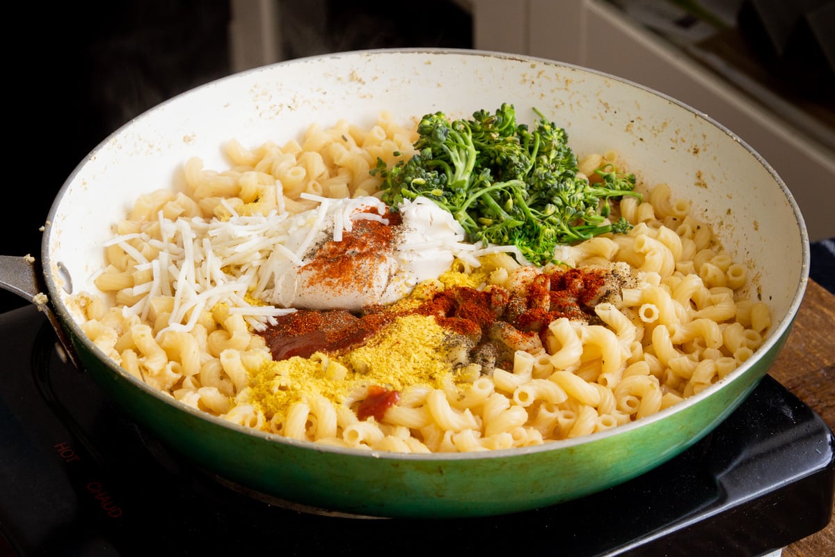 a skillet with cooked pasta and mac and cheese sauce ingredients