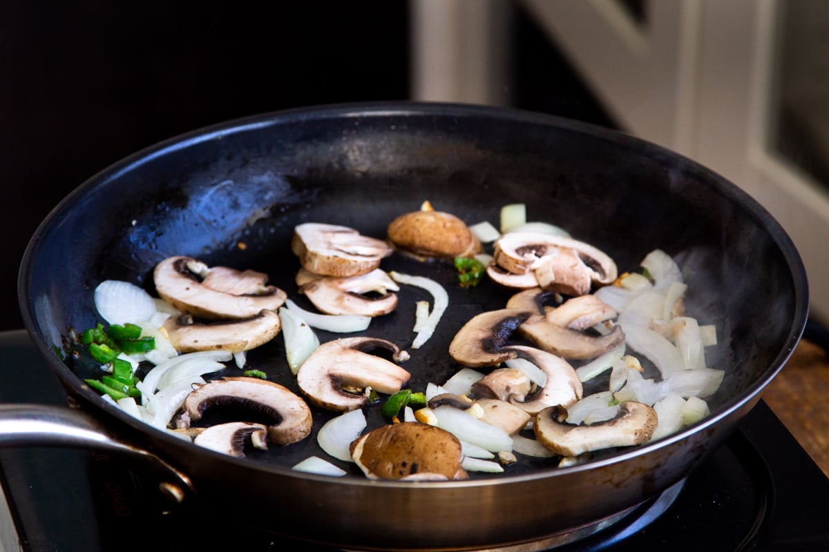 sliced mushrooms, chili and garlic in a black skillet
