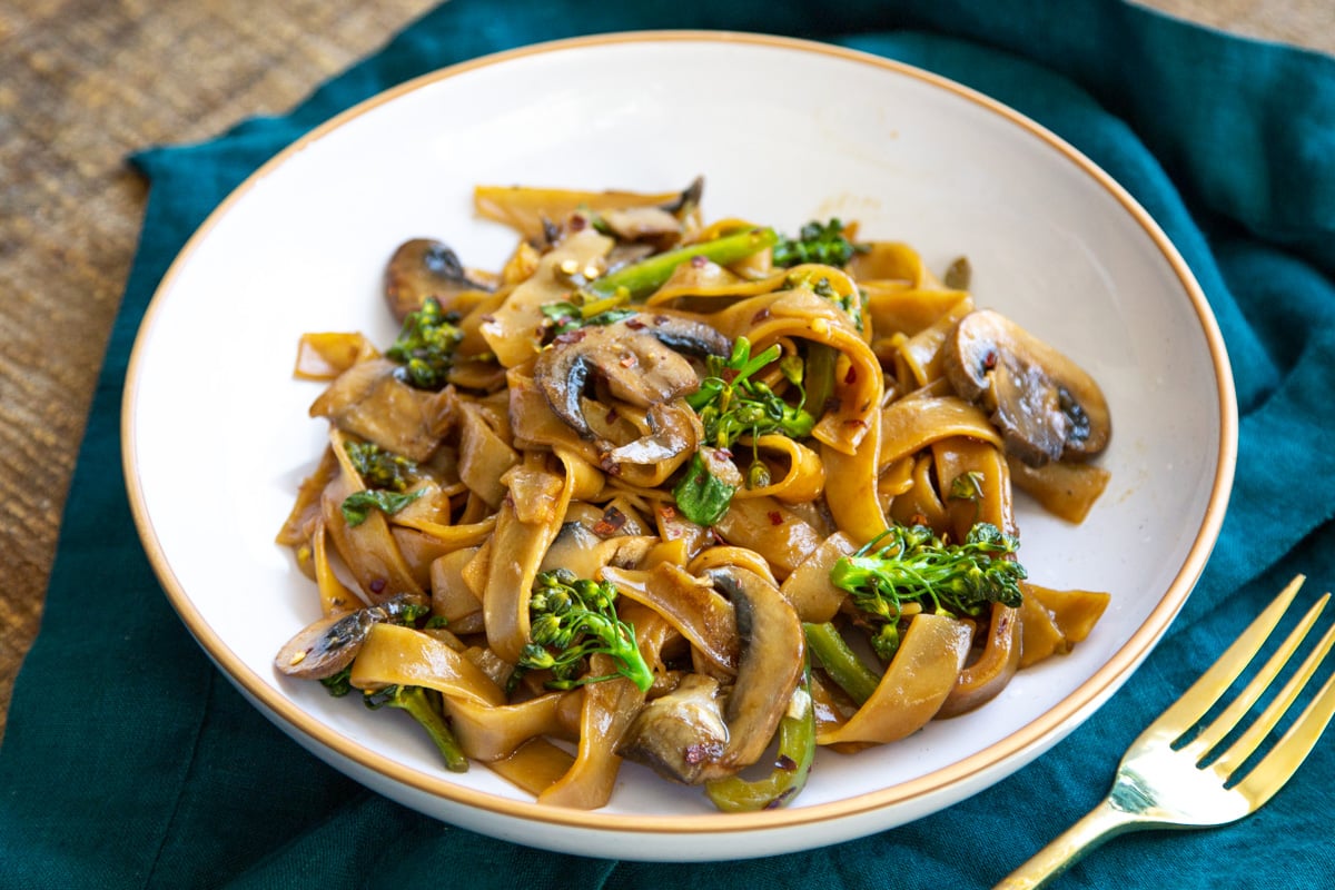 a white plate with vegan Thai Skillet noodles on a blue napkin