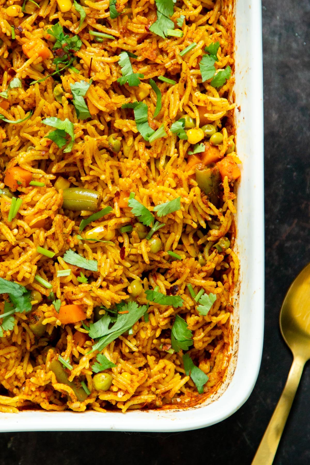 a white casserole dish with rice sprinkled with cilantro