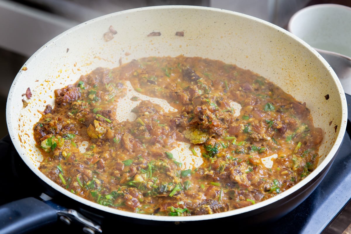a sauteeing pan with base for vegan balti chicken sprinkled with cilantro