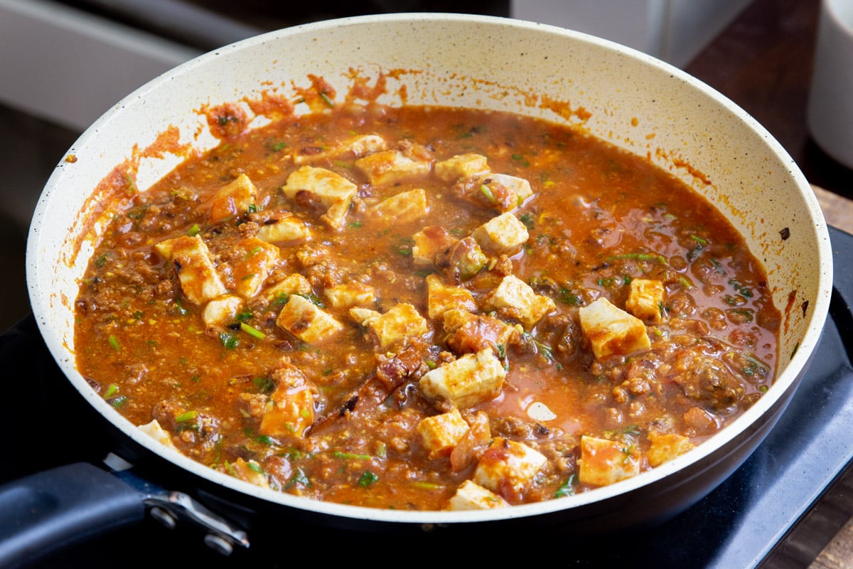 vegan balti chicken with tofu and vegan crumbles simmering in a gravy
