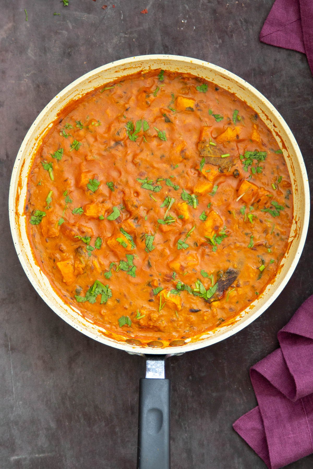 a pan with vegan balti chicken sprinkled with cilantro