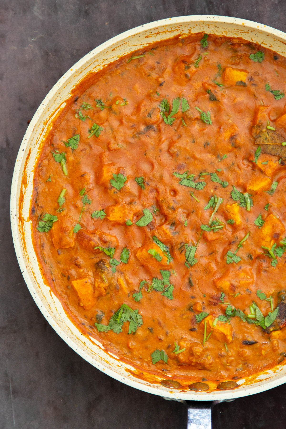 a pan with vegan balti chicken sprinkled with cilantro