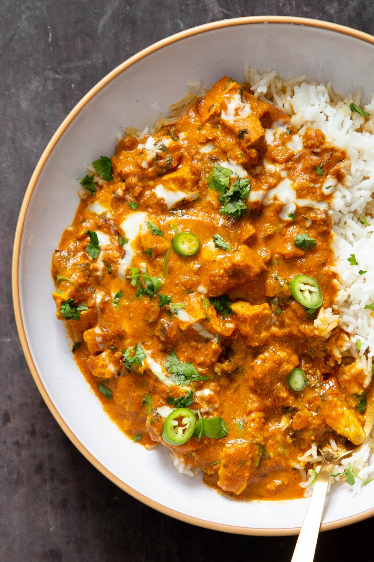 vegan balti chicken served on a white plate with rice and chopped cilantro