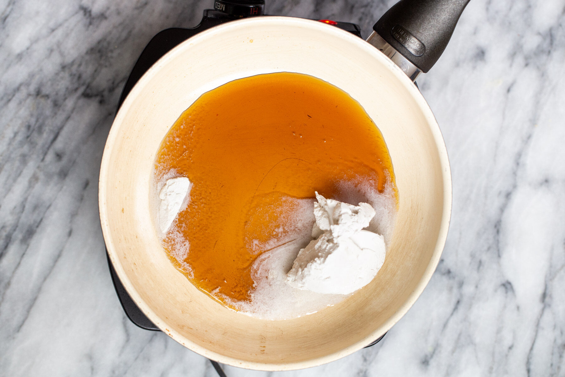 maple syrup and coconut cream in a sauteeing pan