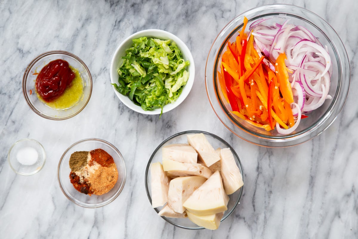 ingredients for vegan jackfruit tacos on a marble countertop