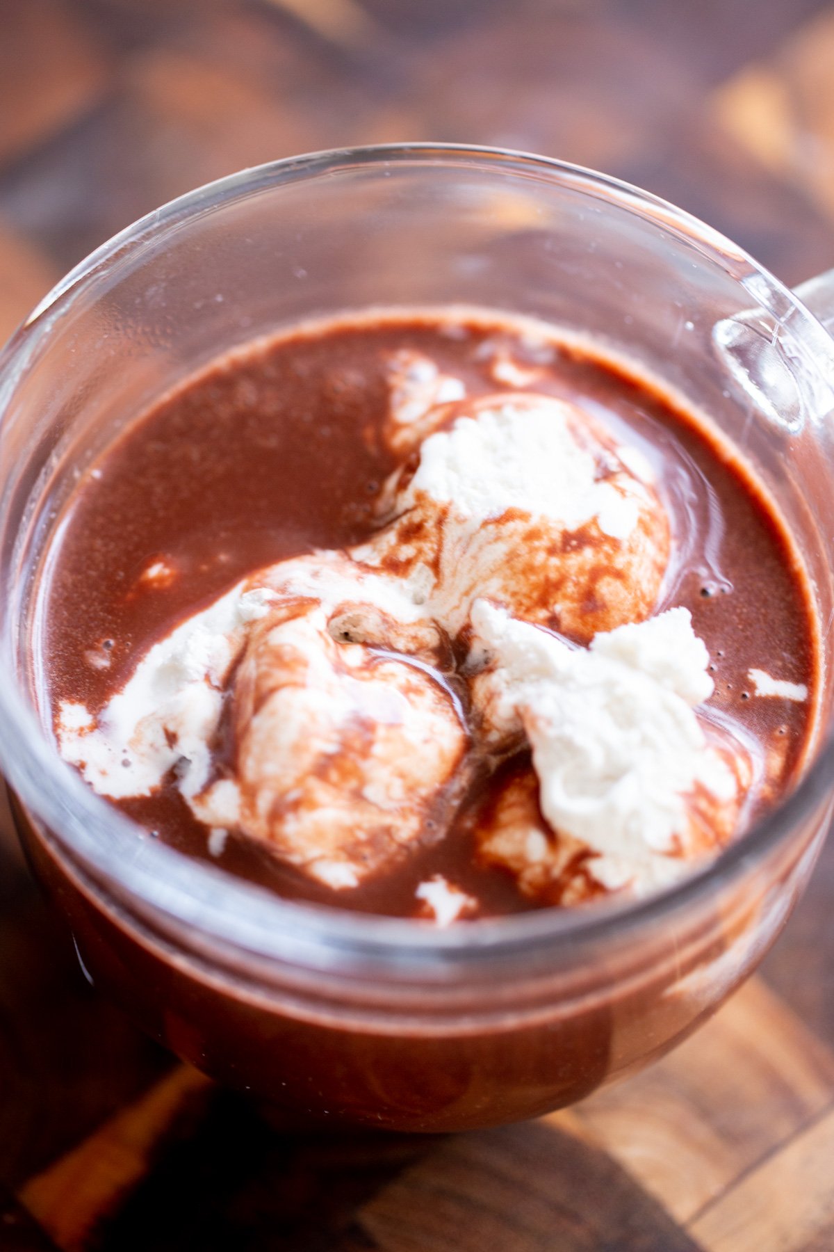 vegan hot chocolate in a glass topped with coconut cream