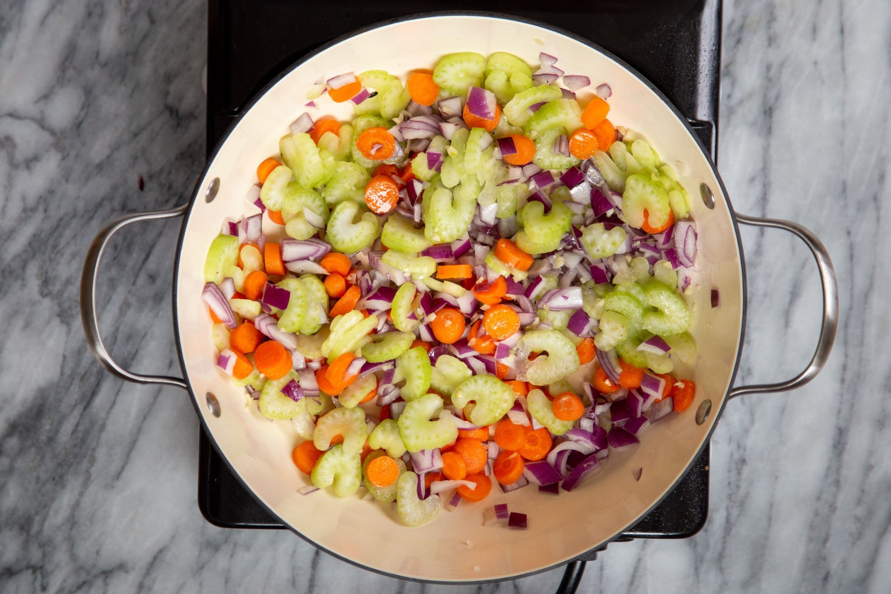 carrots, onions and celery in a sauteeing pan
