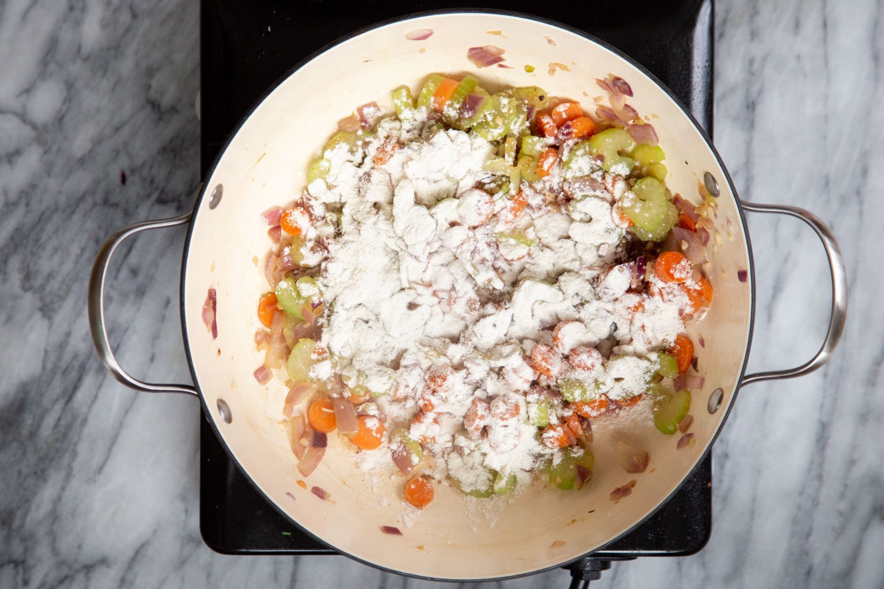 veggies and cornstarch in a saucepan on a cooking plate