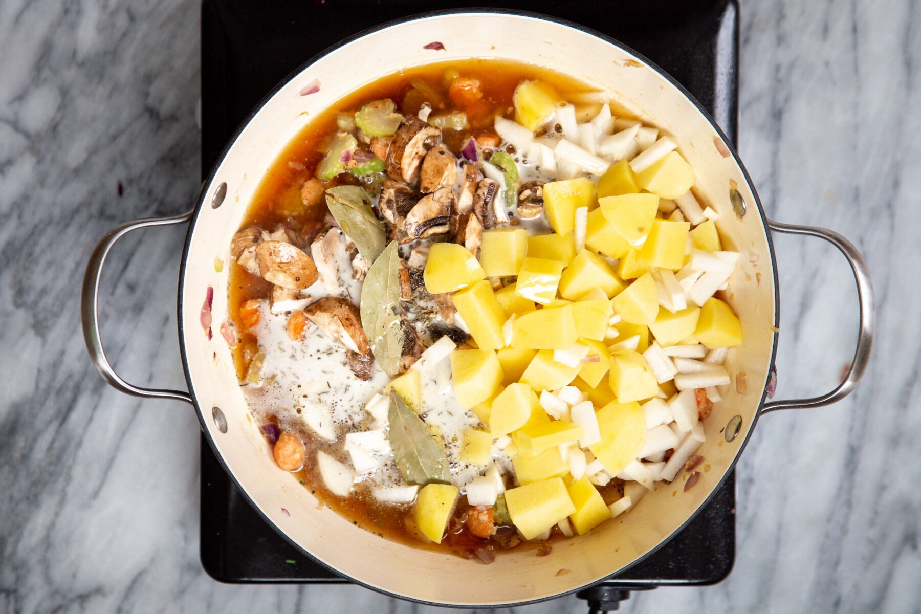 stew ingredients being added to a pot to make vegan Irish Stew