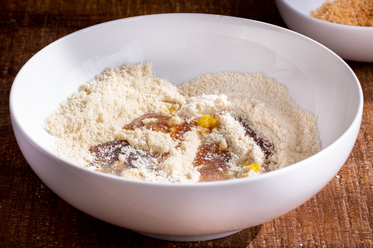 maple syrup and lemon zest being added to a bowl